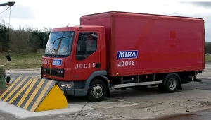 Heavy truck crash-test impact against a PAS 68-rated road blocker, demonstrating hostile vehicle mitigation barrier performance