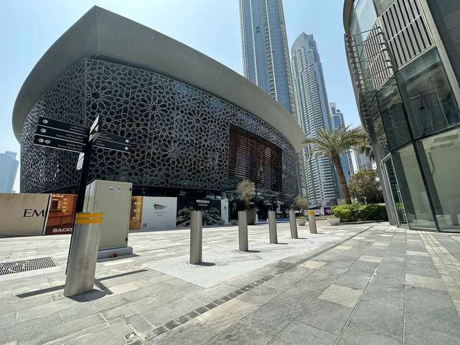 Security bollards protecting a public plaza and commercial building from unauthorized vehicle access.