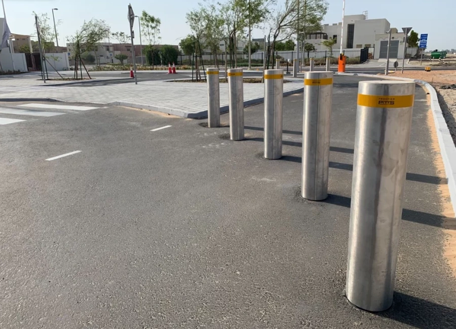 Stainless steel bollards protecting an event access road and supporting vehicle control for pedestrian safety.