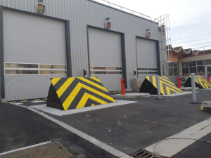 Crash-rated road blockers protecting vehicle access points at an oil and gas or military facility