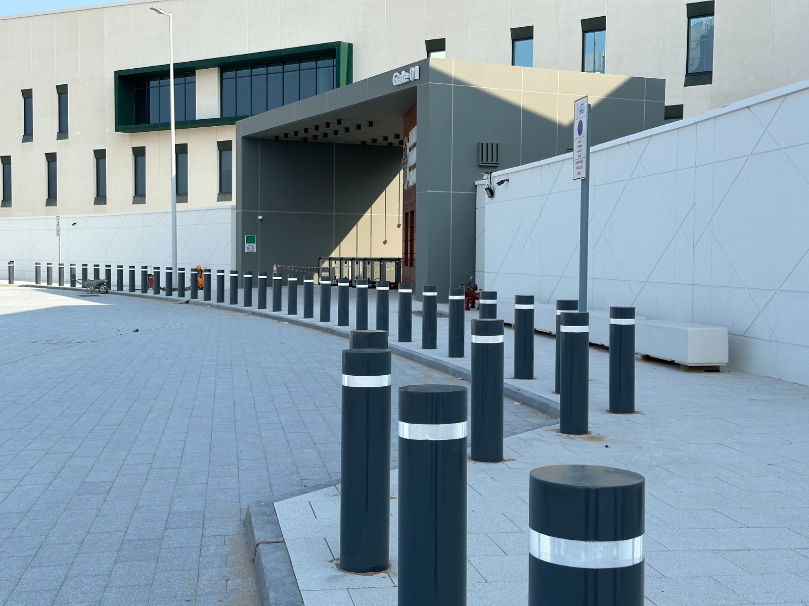 A line of reflective security bollards installed outside a modern building entrance, offering enhanced safety and vehicle restriction while complementing the clean architectural design.