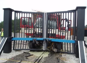 Crash rated gate stopping a heavy vehicle during impact testing for high security perimeter protection.