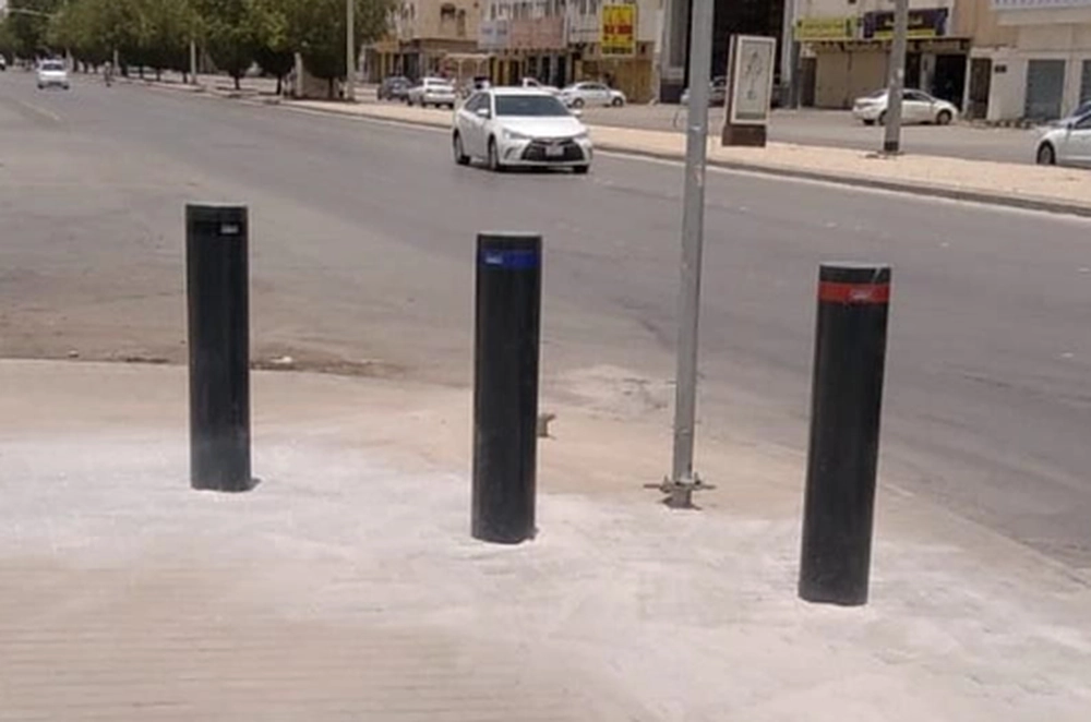 SIRA-approved bollards installed beside a roadside pedestrian area for certified vehicle intrusion protection in the Gulf region.